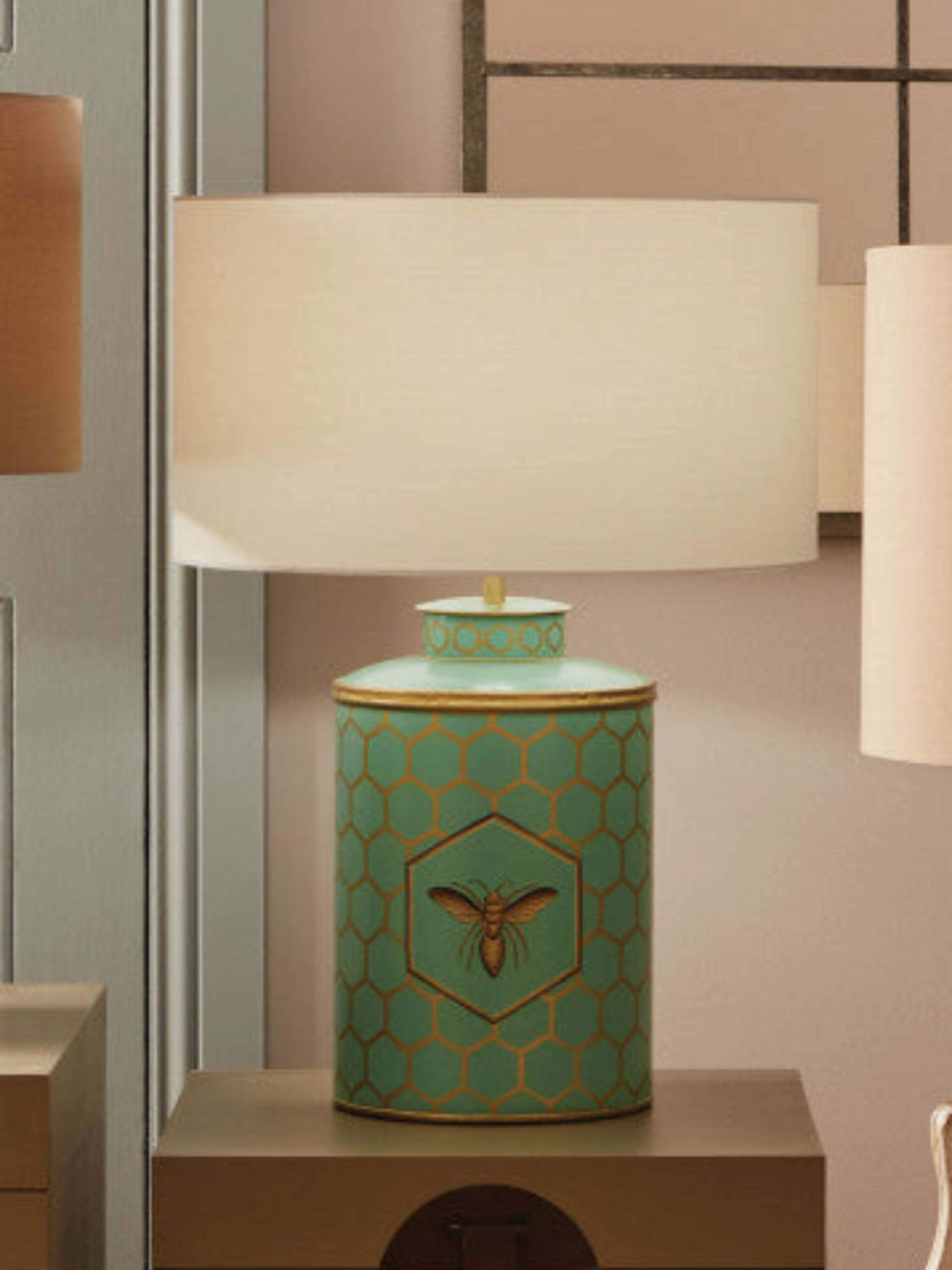 This stunning lamp features a striking aquamarine blue base adorned with gold honeycomb detailing and a beautiful bee motif.